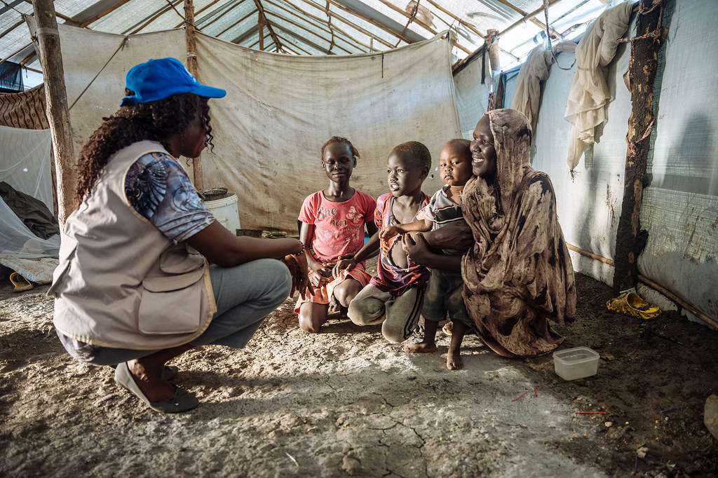 Сотрудница МОМ беседует с семьей беженцев в Южном Судане.